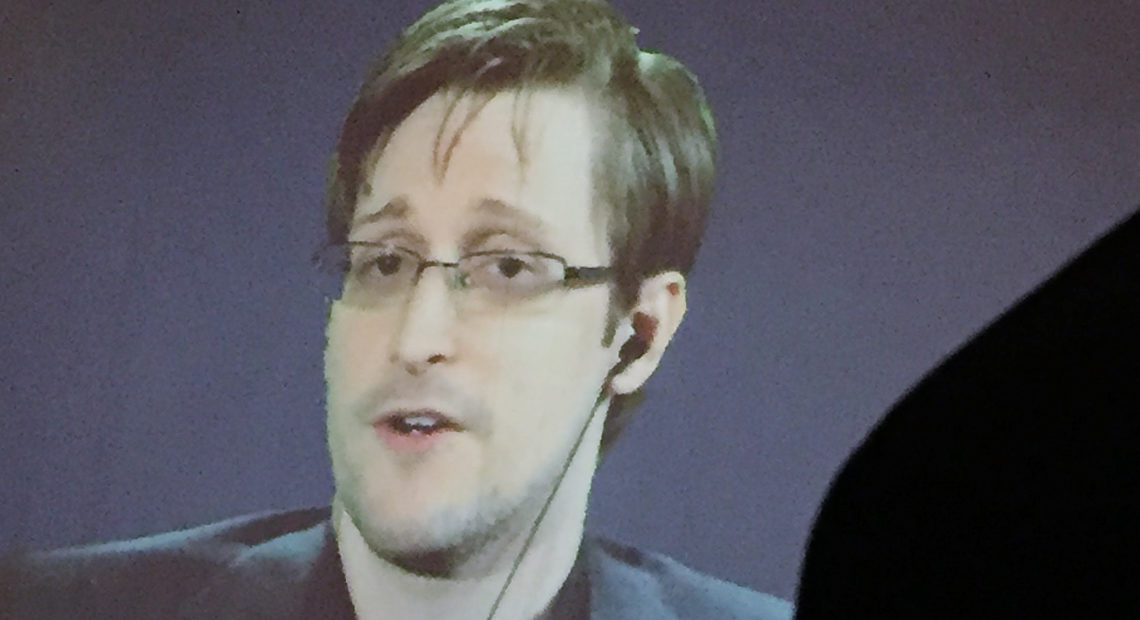 The Justice Department says Edward Snowden, seen here via video feed, breached nondisclosure agreements he signed with the National Security Agency and CIA with the publication of his new memoir, Permanent Record. Juliet Linderman /AP