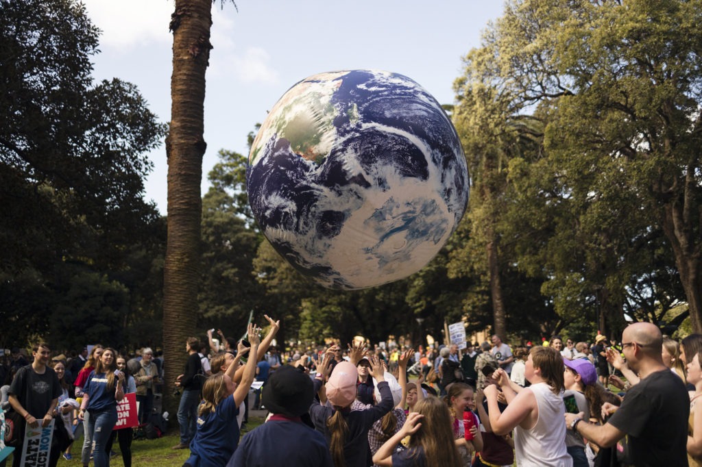 Protesters throw a large globe in Sydney. Rallies held across Australia are part of a global day of action demanding action on the climate crisis. CREDIT: Brook Mitchell/Getty Images