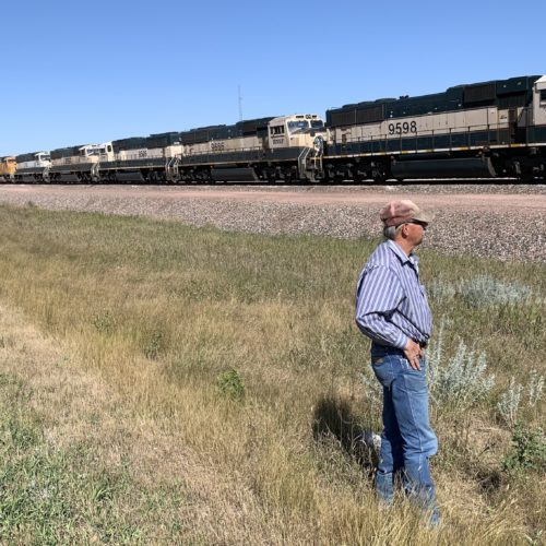 In Gillette, Wyo., miner Bill Fortner stands by stalled trains that normally would be transporting coal. Local production has declined by one-third in the past decade. CREDIT: Cooper McKim/Wyoming Public Media