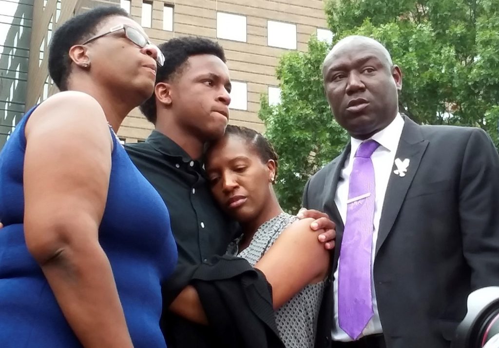 Brandt Jean, center left, brother of shooting victim Botham Jean, hugs his sister Allisa Charles-Findley, during a news conference outside the Frank Crowley Courts Building on Monday, Sept. 10, 2018, in Dallas, about the shooting of Botham Jean by Dallas police officer Amber Guyger on Thursday. He was joined by his mother, Allison Jean, left, and attorney Benjamin Crump, right. Ryan Tarinelli/AP