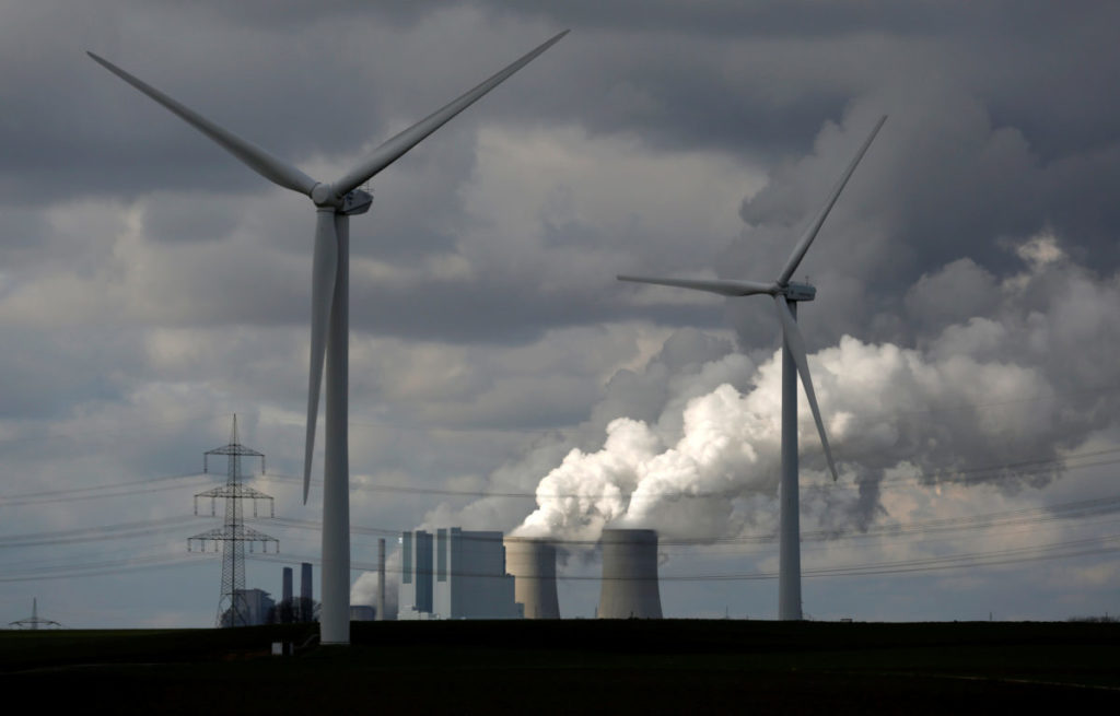 Wind turbines are seen in front of a coal power plant of German utility RWE Power near the western town of Neurath Feb. 28, 2014. CREDIT: Ina Fassbender/Reuters