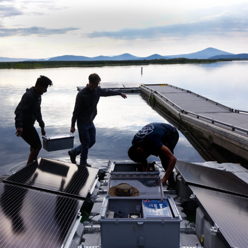 Mohammed Bawazeer and Ian Riley carry a battery that will power the aeration system on Upper Klamath Lake for 32 hours, even if the sun isn't shining.