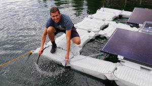 Oregon Institute of Technology student Juan Billarreal holds the aeration hose that will add dissolved oxygen to Upper Klamath Lake.