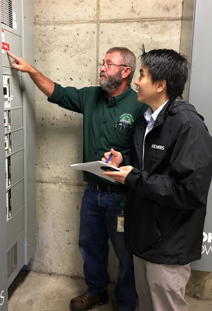 Coquille Valley Hospital plant operations director Ernie Fegles, left, and Andreas Winardi of Siemens discussed how a microgrid might work during a site visit on Sept. 26. Courtesy of Couquille Valley Hospital