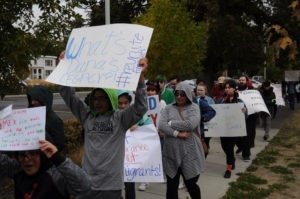 Jesus Zepeda Salas marches in Ellensburg Sunday, Sept. 29, holding a sign challenging Kittitas County Sheriff Gene Dana’s legacy as the longest-serving sheriff in Washington State. Immigration rights advocates called on Dana to cancel a contract with Immigration and Customs Enforcement before his retirement in October. CREDIT: Enrique Pérez de la Rosa/NWPB