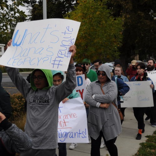 Jesus Zepeda Salas marches in Ellensburg Sunday, Sept. 29, holding a sign challenging Kittitas County Sheriff Gene Dana’s legacy as the longest-serving sheriff in Washington State. Immigration rights advocates called on Dana to cancel a contract with Immigration and Customs Enforcement before his retirement in October. CREDIT: Enrique Pérez de la Rosa/NWPB