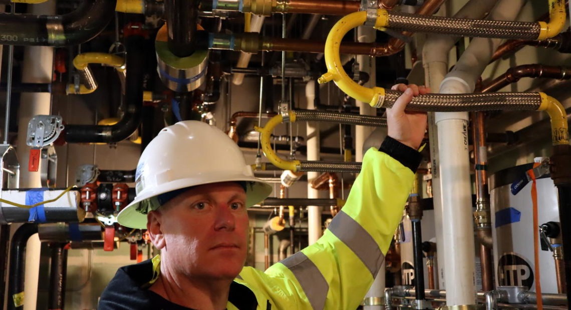 Samaritan North Lincoln Hospital facilities director Chris Lemar shows flexible piping designed to withstand earthquake shaking in the new hospital. CREDIT: Tom Banse/N3