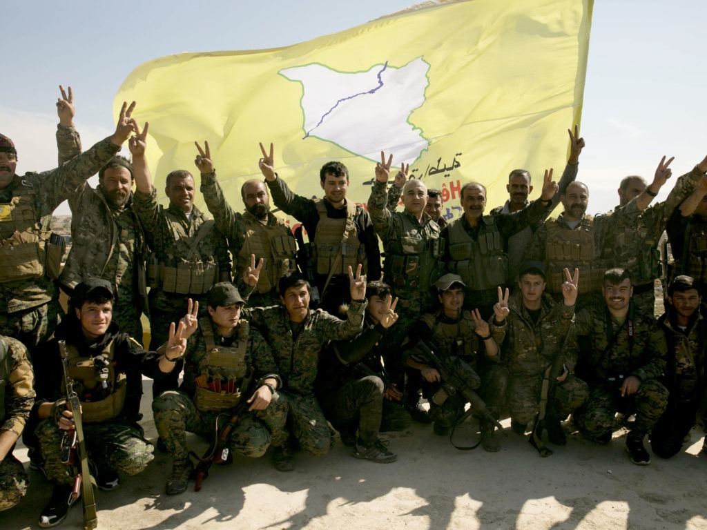 U.S.-backed Syrian Democratic Forces (SDF) fighters pose for a photo in Baghouz, Syria, in March after the SDF declared the area free of Islamic State militants. CREDIT: Maya Alleruzzo/AP