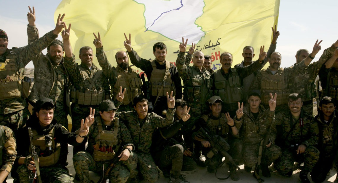 U.S.-backed Syrian Democratic Forces (SDF) fighters pose for a photo in Baghouz, Syria, in March after the SDF declared the area free of Islamic State militants. CREDIT: Maya Alleruzzo/AP