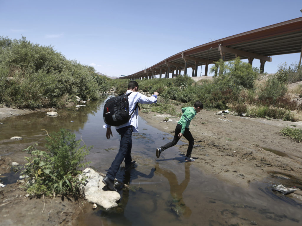 Migrants cross the Rio Grande into the United States, to turn themselves over to authorities and ask for asylum, in Ciudad, Juarez, in June. CREDIT: Christian Torres/AP