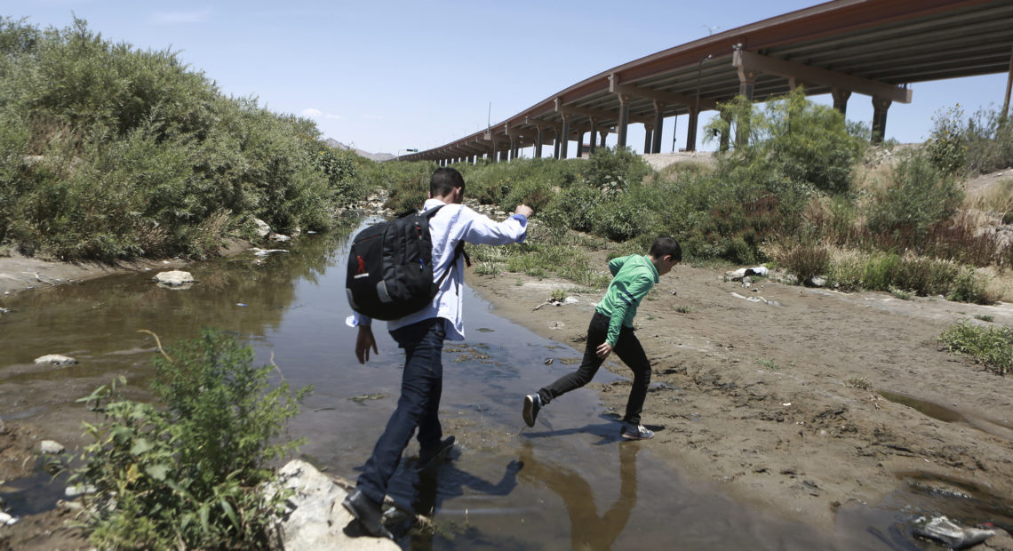 Migrants cross the Rio Grande into the United States, to turn themselves over to authorities and ask for asylum, in Ciudad, Juarez, in June. CREDIT: Christian Torres/AP