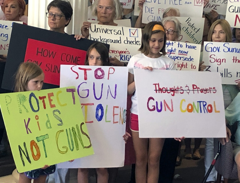 Supporters of gun control measures gather at the Legislative Office Building in Concord, N.H., in August, to urge Republican Gov. Chris Sununu to act after mass shootings in Texas and Ohio. CREDIT: Michael Casey/AP