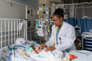 Nathaly Sweeney, a neonatologist at Rady Children's Hospital-San Diego and researcher with Rady Children's Institute for Genomic Medicine, attends to a young patient in the hospital's neonatal intensive care unit.