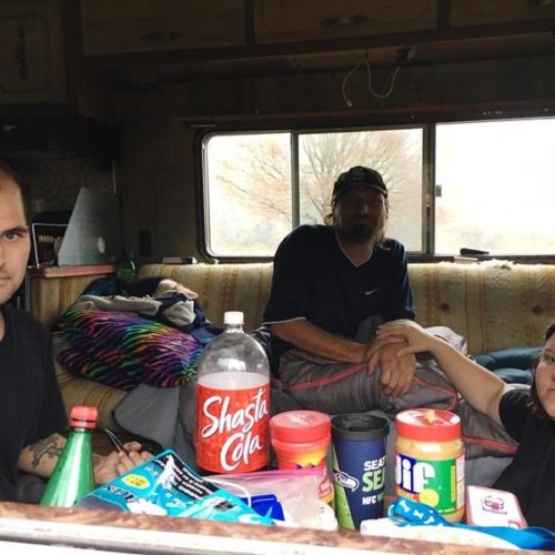 Austin Hall, left, his fiance Victoria Swan and a man who identified himself as Mark Goddard sit in one of the RVs parked on Deschutes Parkway on Washington's Capitol campus. CREDIT: Austin Jenkins/N3