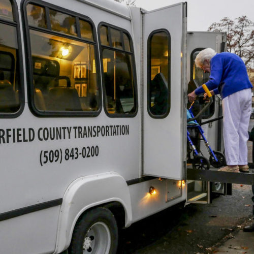 Garfield County Transportation Authority driver Gene Smith helps 96-year-old resident Louise Munday board a commuter bus on Nov. 15, 2019. Munday uses local transit five days a week and, with her limited mobility, the service to her door is necessary. CREDIT: Emily McCarty/Crosscut