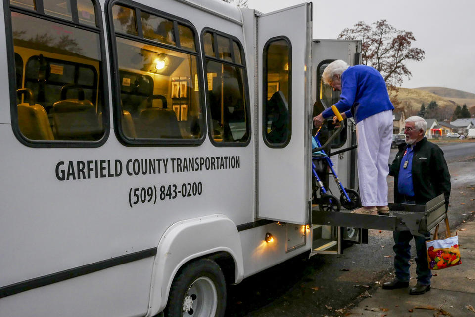 Garfield County Transportation Authority driver Gene Smith helps 96-year-old resident Louise Munday board a commuter bus on Nov. 15, 2019. Munday uses local transit five days a week and, with her limited mobility, the service to her door is necessary. CREDIT: Emily McCarty/Crosscut