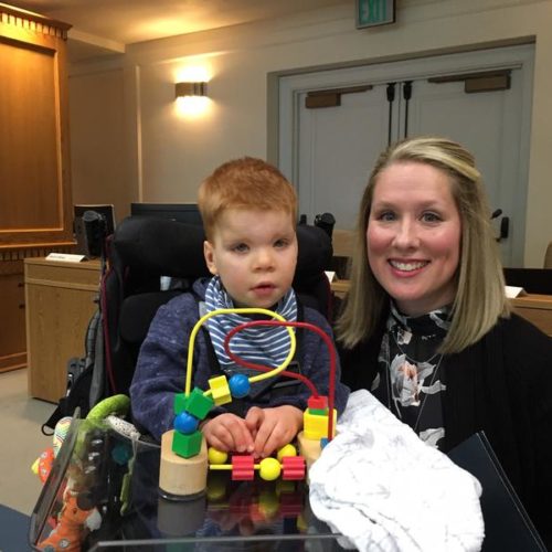 Lindsey Topping-Schuetz poses for a photo with her three-year-old son Owen before testifying about the challenges families face in obtaining state-paid developmental disabilities services.