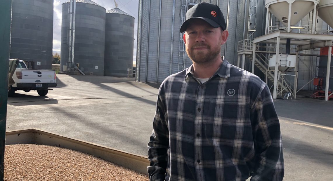 Kyle Hinrichs helps run the family business outside of Pullman, Wash. Right now the company is drying beans as fast as possible with several machines, but it’s an around the clock job. CREDIT: Anna King/N3