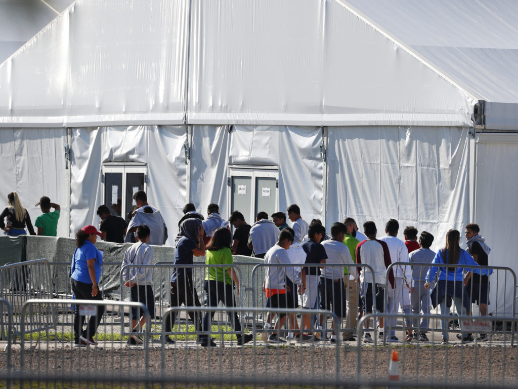 Migrant children line up to enter a tent at the Homestead Temporary Shelter for Unaccompanied Children in Homestead, Fla. in February 2019. CREDIT: Wilfredo Lee/AP