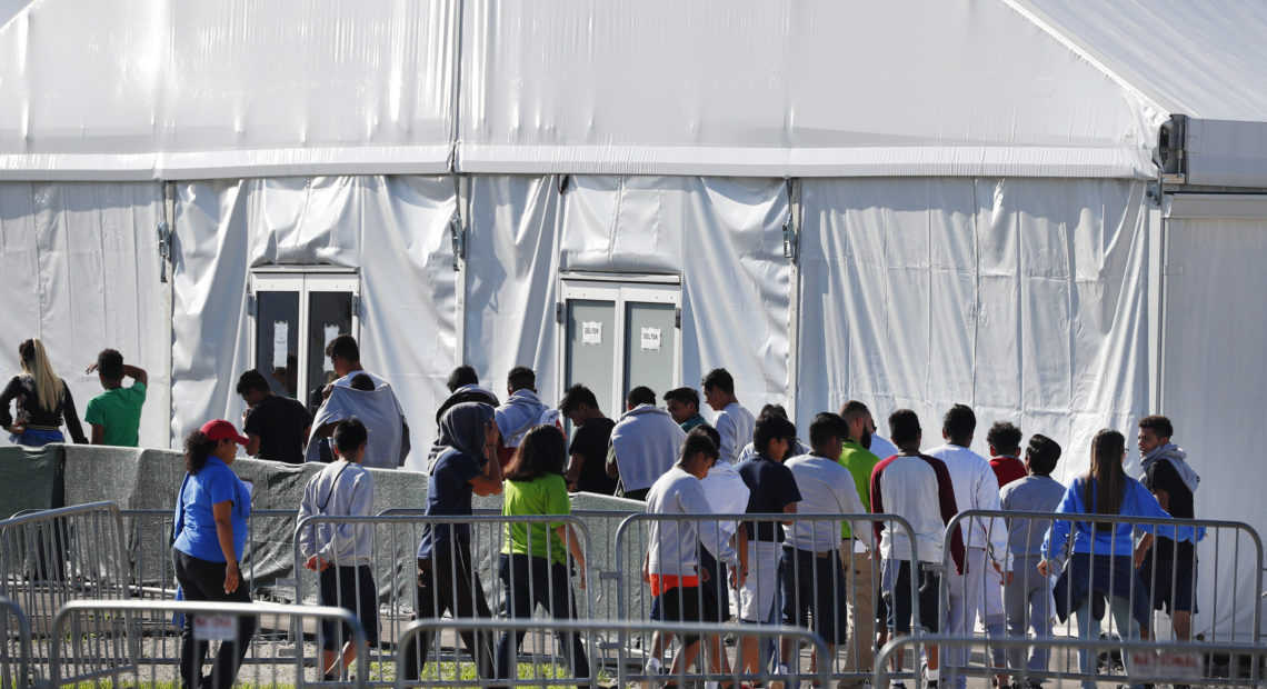 Migrant children line up to enter a tent at the Homestead Temporary Shelter for Unaccompanied Children in Homestead, Fla. in February 2019. CREDIT: Wilfredo Lee/AP