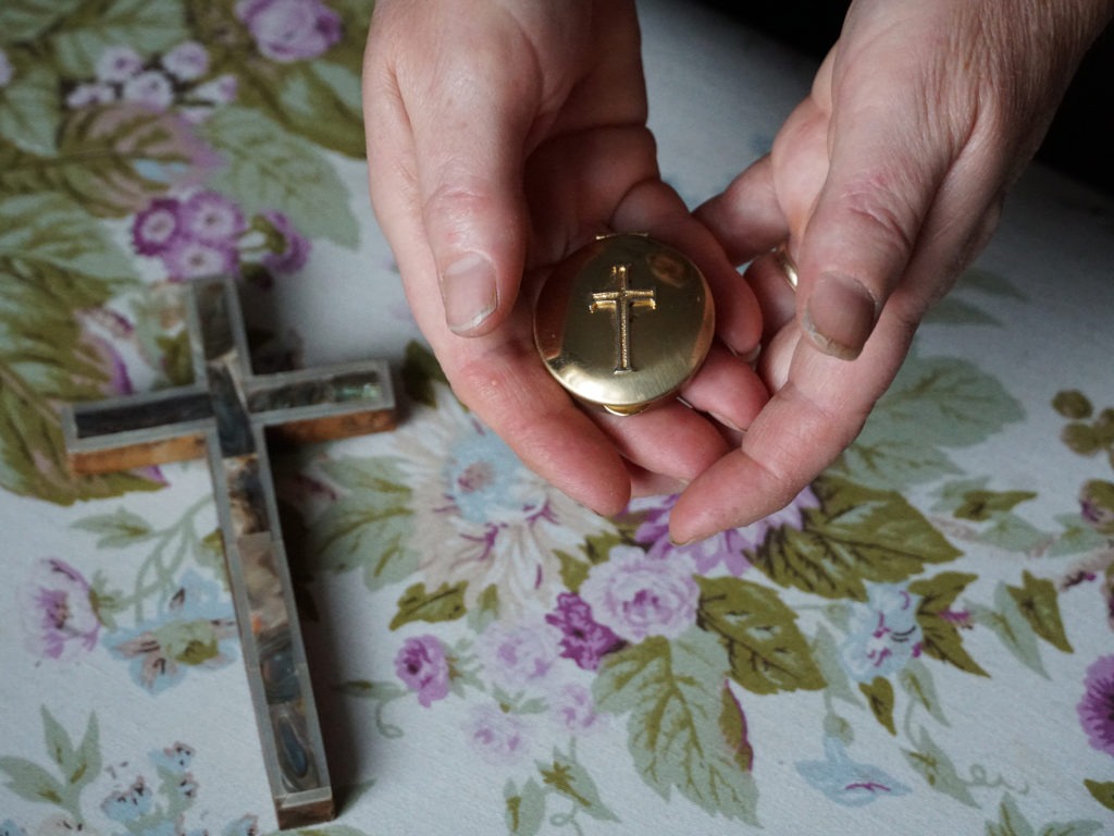 Marie Andrews holds a pyx, the vessel she uses to transport the consecrated Communion wafer to homebound parishioners. Andrews is an officially sanctioned Eucharistic minister in the Roman Catholic Church. CREDIT: Shahla Farzan/St. Louis Public Radio