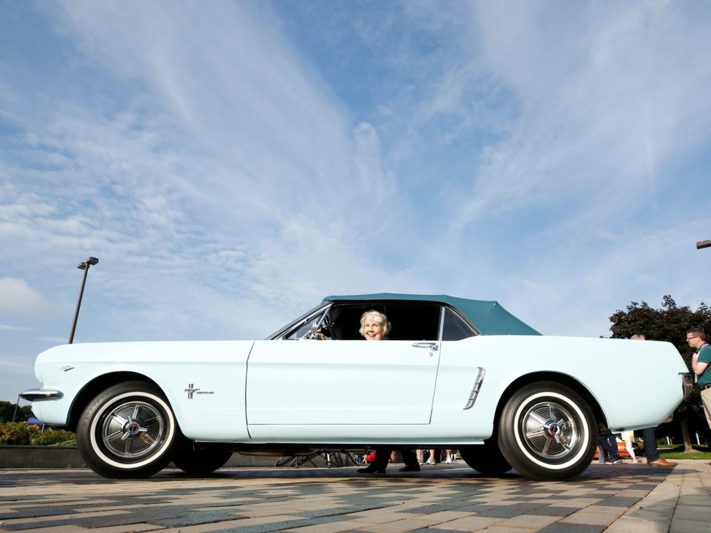 Gail Wise sits in her 1964 Mustang as Ford celebrates the production of the 10 millionth Mustang at in August 2018. CREDIT: Jeff Kowalsky/AFP via Getty Images