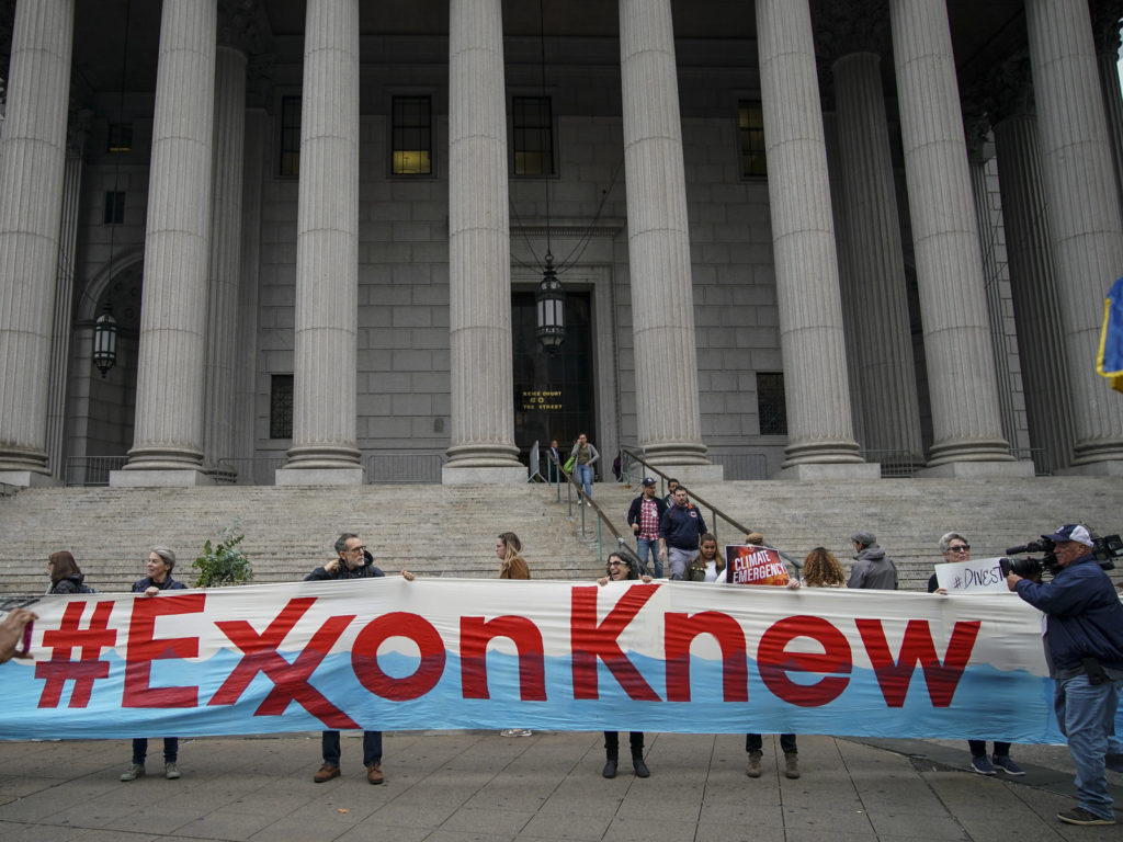Environmental activists rally outside of New York Supreme Court in October in Manhattan, the first day of the trial accusing ExxonMobil of misleading shareholders about its climate change accounting. CREDIT: Drew Angerer/Getty Images