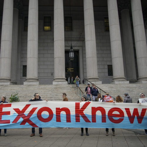 Environmental activists rally outside of New York Supreme Court in October in Manhattan, the first day of the trial accusing ExxonMobil of misleading shareholders about its climate change accounting. CREDIT: Drew Angerer/Getty Images