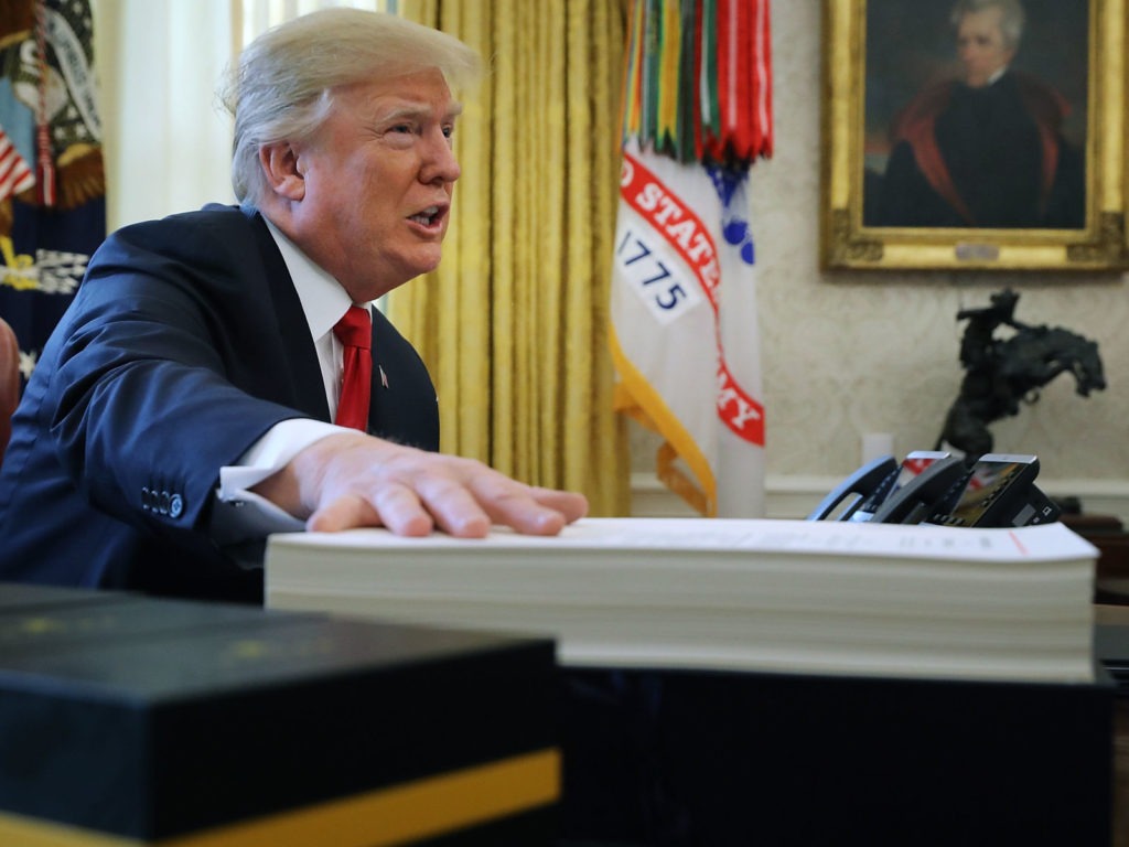 President Trump prepares to sign the tax legislation in the Oval Office on Dec. 22, 2017. The GOP tax cut did not pay for itself, as promised, nor did it deliver a sustained boost to economic growth. CREDIT: Chip Somodevilla/Getty Images