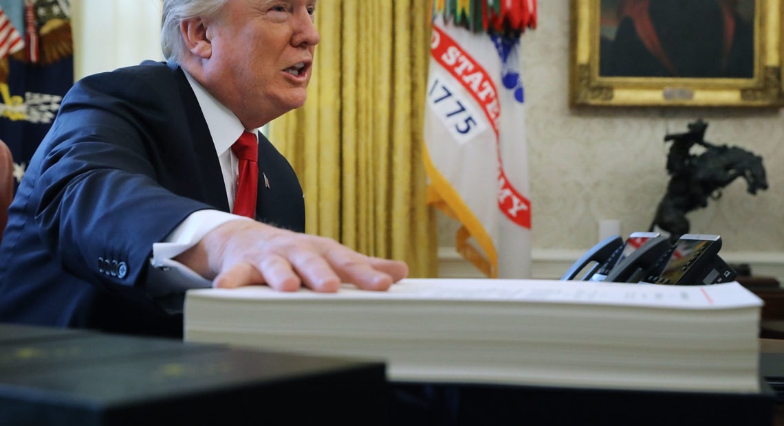 President Trump prepares to sign the tax legislation in the Oval Office on Dec. 22, 2017. The GOP tax cut did not pay for itself, as promised, nor did it deliver a sustained boost to economic growth. CREDIT: Chip Somodevilla/Getty Images