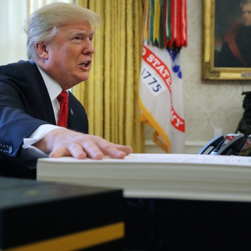 President Trump prepares to sign the tax legislation in the Oval Office on Dec. 22, 2017. The GOP tax cut did not pay for itself, as promised, nor did it deliver a sustained boost to economic growth. CREDIT: Chip Somodevilla/Getty Images