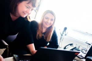 Reporter Anna King teaches a student how to edit audio on a computer.