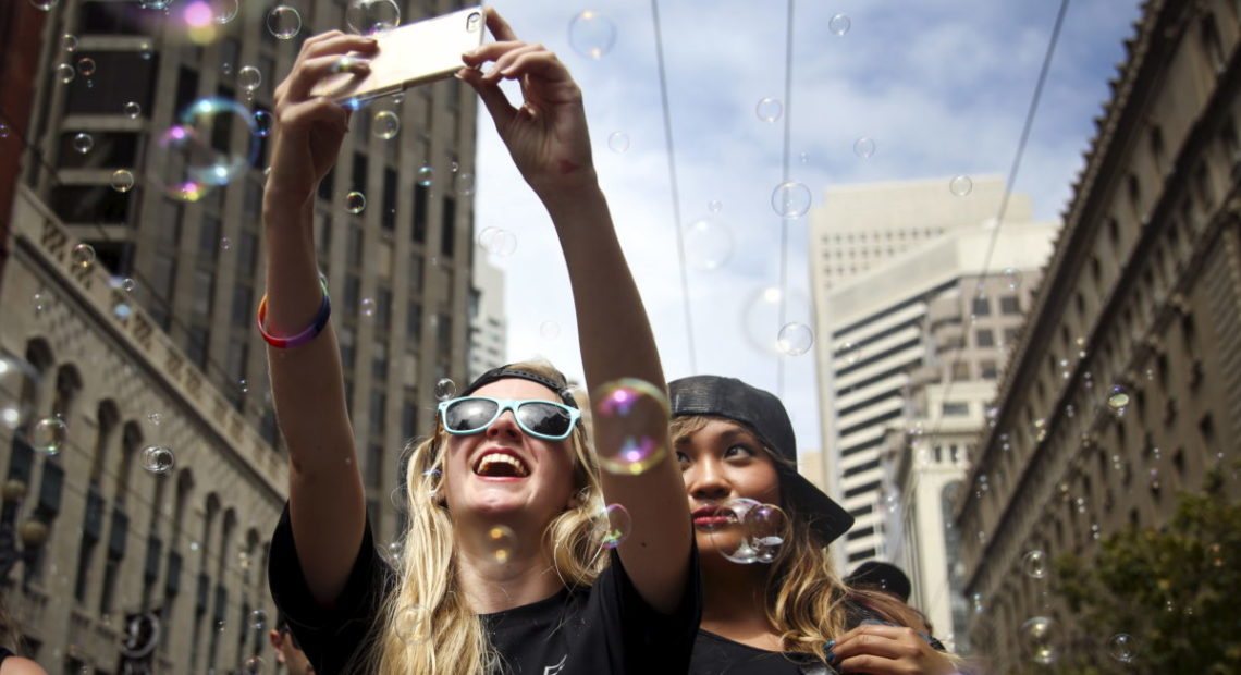 Two women take a selfie while marching in a Pride parade in San Francisco, California June 28, 2015. CREDIT: Nouvelage/Reuters