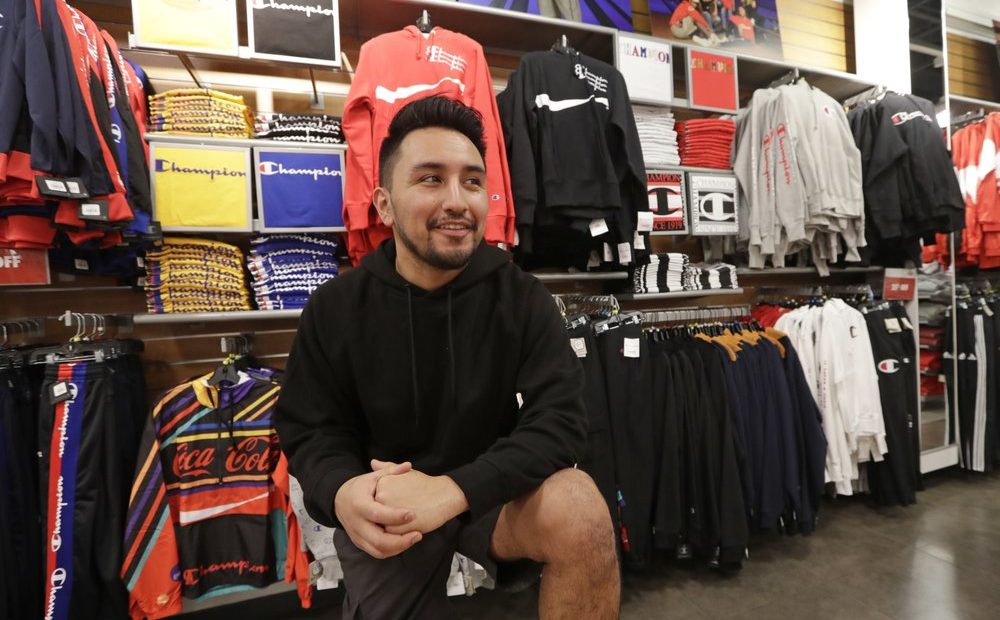 Victor Duran, a co-manager of a sports apparel store at the Southcenter mall, south of Seattle. Duran is one employee who could benefit from new overtime rules in Washington, which will allow hundreds of thousands of workers who have been exempt to begin collecting when they work more than 40 hours per week. CREDIT: Elaine Thompson/AP