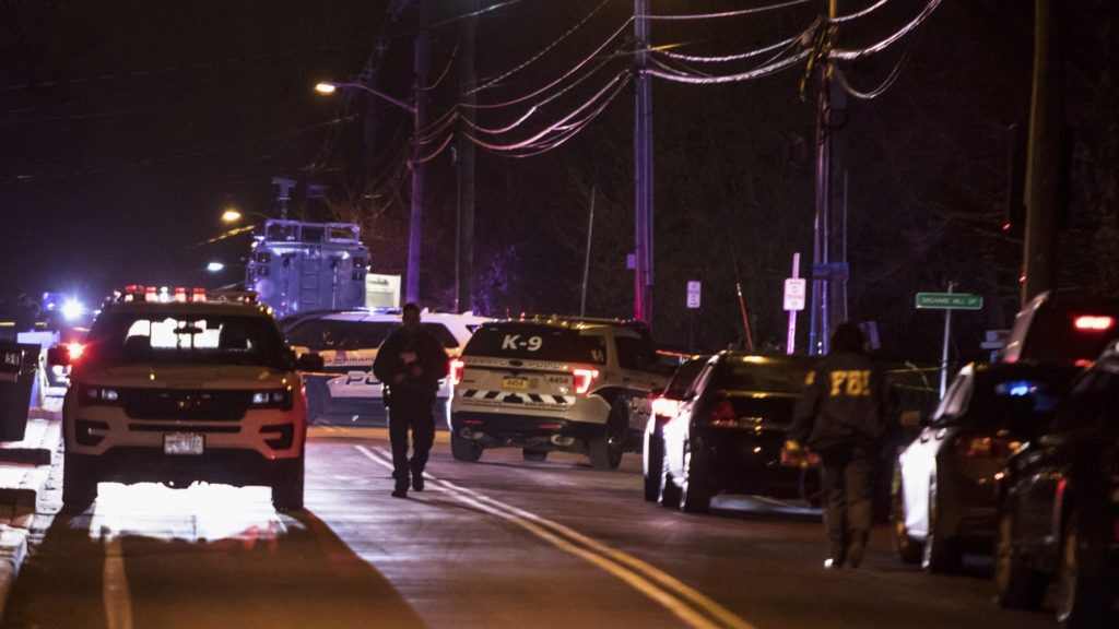 Authorities gather on a street in Monsey, N.Y., Sunday following a stabbing late Saturday during a Hanukkah celebration. CREDIT: Allyse Pulliam/AP