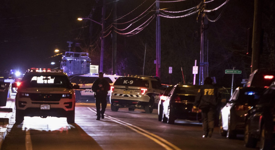 Authorities gather on a street in Monsey, N.Y., Sunday following a stabbing late Saturday during a Hanukkah celebration. CREDIT: Allyse Pulliam/AP