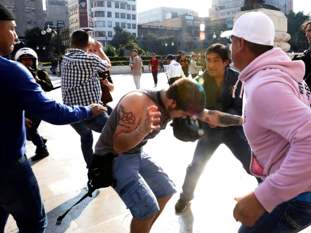 A group of people, who are part of a farm union, block the entrance of the Fine Arts Palace as they fight with LGBTQ supporters about a painting showing Mexican revolutionary hero Emiliano Zapata nude while wearing high heels and riding a horse, in Mexico City, Mexico. CREDIT: Carlos Jasso/Reuters