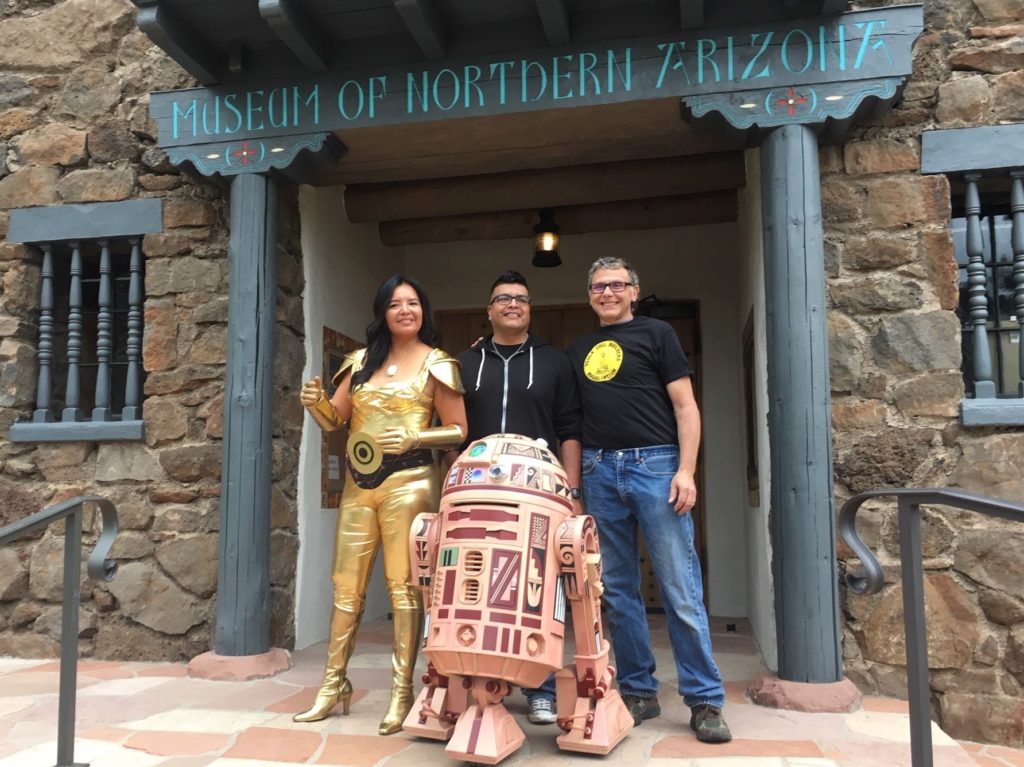 Geri Hongeva (left), who voiced C-3PO in the Navajo translation of A New Hope; artist Duane Koyawena (center); and engineer Joe Mastroianni with Hopi R2 at the Museum of Northern Arizona in Flagstaff. CREDIT: Ryan Heinsius/KNAU