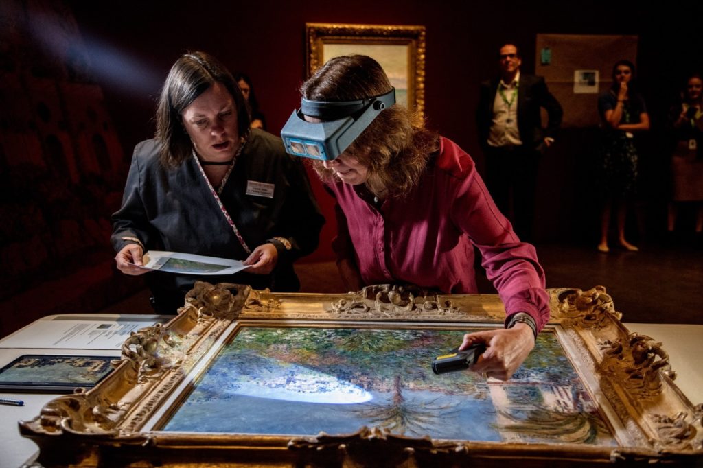 Conservator Felicitas Klein, right, traveled from Germany with Villas at Bordighera, an 1884 painting by Claude Monet. She inspects the painting at the Denver Art Museum, along with senior paintings conservator Pamela Skiles. Kendelyn Ouellette