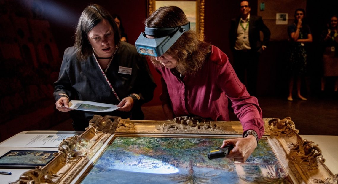Conservator Felicitas Klein, right, traveled from Germany with Villas at Bordighera, an 1884 painting by Claude Monet. She inspects the painting at the Denver Art Museum, along with senior paintings conservator Pamela Skiles. Kendelyn Ouellette