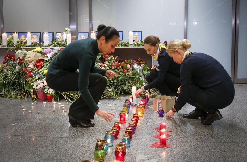 Colleagues of the flight crew members of the Ukrainian 737-800 plane that crashed on the outskirts of Tehran, light candles at a memorial inside Borispil International Airport near Kyiv. CREDIT: Efrem Lukatsky/AP