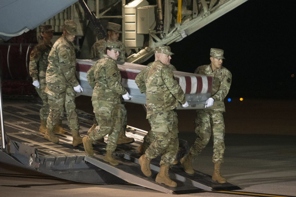 An Air Force team moves a transfer case containing the remains of one of the young sailors killed after a Saudi military student opened fire at a Pensacola naval base last month. Officials are expected to soon announce that about 12 Saudi military students will be expelled from the U.S. CREDIT: Cliff Owen/AP