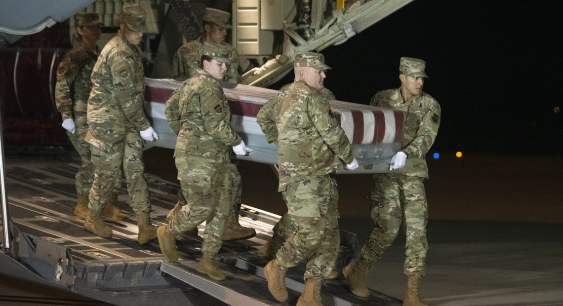 An Air Force team moves a transfer case containing the remains of one of the young sailors killed after a Saudi military student opened fire at a Pensacola naval base last month. Officials are expected to soon announce that about 12 Saudi military students will be expelled from the U.S. CREDIT: Cliff Owen/AP