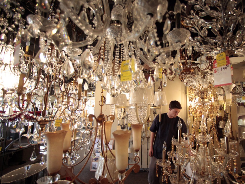 Jack George, an employee at Royal Lighting, looks at chandeliers using incandescent light bulbs at the store in Los Angeles. A federal judge is allowing California to enforce updated efficiency standards that will affect such specialty lightbulbs. CREDIT: Jae C. Hong/AP