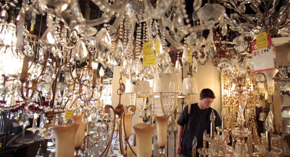 Jack George, an employee at Royal Lighting, looks at chandeliers using incandescent light bulbs at the store in Los Angeles. A federal judge is allowing California to enforce updated efficiency standards that will affect such specialty lightbulbs. CREDIT: Jae C. Hong/AP