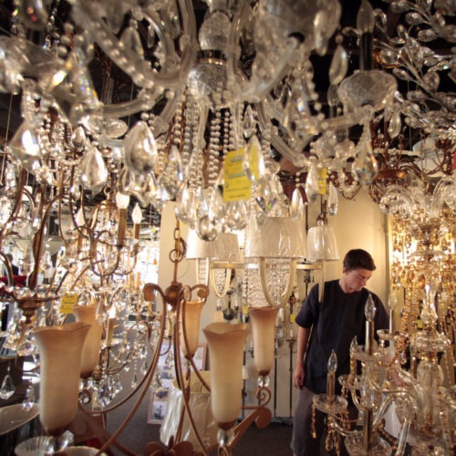 Jack George, an employee at Royal Lighting, looks at chandeliers using incandescent light bulbs at the store in Los Angeles. A federal judge is allowing California to enforce updated efficiency standards that will affect such specialty lightbulbs. CREDIT: Jae C. Hong/AP