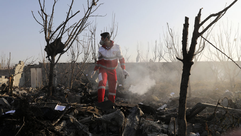 A rescue worker searches the scene where a Ukrainian plane crashed near Tehran on Wednesday, killing all on board. Iranian state TV reported Saturday that the military mistakenly shot the plane down. Ebrahim Noroozi/AP