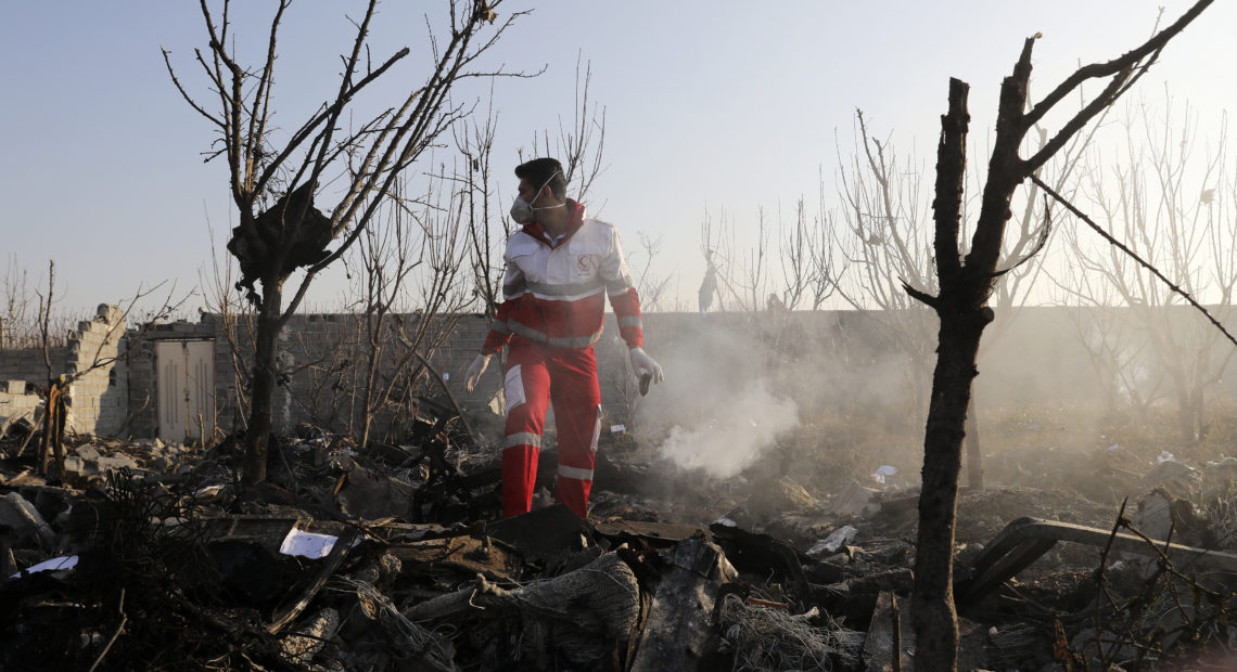 A rescue worker combs the wreckage of a Ukraine International Airlines plane near Iran's Imam Khomeini International Airport on Wednesday. All 176 people on board died in the crash, which Ukraine is now investigating.