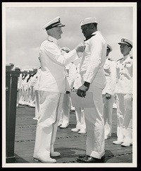 Admiral Chester W. Nimitz, Commander-in-Chief of the U.S. Pacific Fleet, pins the Navy Cross on Miller at a ceremony on board a U.S. Navy warship in Pearl Harbor on May 27, 1942. CREDIT: Library of Congress