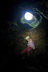 Girl repels into a cave.